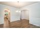 Bright dining room with archways, stylish wainscoting, wood floors, and modern chandelier at 150 W Morehouse Ave, Mooresville, NC 28117