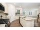 Open kitchen with an island featuring granite counters, stainless appliances, and wood flooring at 150 W Morehouse Ave, Mooresville, NC 28117