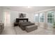 This modern main bedroom features a luxurious bed, a bench, neutral decor, and a lot of natural light at 150 W Morehouse Ave, Mooresville, NC 28117
