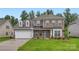 Charming two-story home with a brick and siding facade, a well-manicured lawn, and an attached two-car garage at 1540 Croydon St, Indian Land, SC 29707
