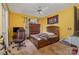 A bedroom with yellow walls, ceiling fan, and a bed with a red gaming chair at 159 Pitts School Nw Rd, Concord, NC 28027