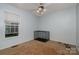 A simple carpeted bedroom with a large window, ceiling fan and pet kennel at 159 Pitts School Nw Rd, Concord, NC 28027