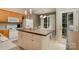 Well-lit kitchen with an island, white appliances, adjacent dining area, and a door leading to the outside at 159 Pitts School Nw Rd, Concord, NC 28027