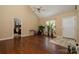 Hardwood living room featuring a ceiling fan, large windows, and easy access to the front door and other rooms at 159 Pitts School Nw Rd, Concord, NC 28027