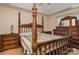 A spacious main bedroom featuring an ornate four poster bed, tray ceiling, and a ceiling fan at 159 Pitts School Nw Rd, Concord, NC 28027