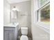 A clean bathroom features a vanity with gray cabinets and a toilet under the window at 1606 Northwoods Dr, Kings Mountain, NC 28086