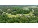 Expansive aerial shot of a home nestled among trees, revealing a peaceful rural community at 1691 Hill River Rd, Hiddenite, NC 28636