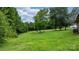 Vast backyard featuring a lush green lawn surrounded by mature trees at 1691 Hill River Rd, Hiddenite, NC 28636