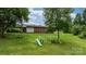 Expansive backyard with green lawn, mature trees, and a swing set at 1691 Hill River Rd, Hiddenite, NC 28636