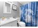 This bathroom has a white sink and toilet, along with a unique shower curtain at 1691 Hill River Rd, Hiddenite, NC 28636