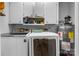 This laundry room has white washer and dryer units with white cabinets at 1691 Hill River Rd, Hiddenite, NC 28636