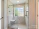 Shower with glass door and window, tiled walls, and a built-in seat at 185 Eastcliff Se Dr, Concord, NC 28025