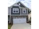 Two-story home featuring a two-car garage, stone accents, gray siding, and well-manicured lawn at 1922 Highland Park Dr, Charlotte, NC 28269