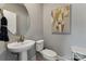 Elegant powder room features a pedestal sink, round mirror, and stylish artwork enhancing the space at 1944 Westerhill Dr, Fort Mill, SC 29708