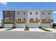Rear view of modern townhomes with private garages and wooden decks overlooking green space at 1944 Westerhill Dr, Fort Mill, SC 29708