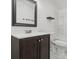A well lit bathroom featuring a dark wood vanity, white sink, toilet, shower, and black trimmed mirror at 2315 Circle Dr, Great Falls, SC 29055