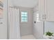 Clean and modern tiled shower with crisp white shower curtain, window, and updated fixtures in bathroom at 3308 Selwyn Farms Ln # 5, Charlotte, NC 28209