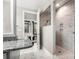 Modern bathroom with white marble tile, glass shower enclosure, granite countertops, and view to bedroom at 4189 Island Fox Ln, Denver, NC 28037