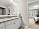 Bright bathroom with white vanity, granite counters, and large mirror, offering a clean, stylish aesthetic at 4189 Island Fox Ln, Denver, NC 28037