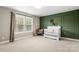 Charming Bedroom with green accent wall, white crib, and a large window at 4189 Island Fox Ln, Denver, NC 28037