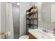 Well-lit bathroom featuring a shower with gray tile and dark shelving at 4230 Train Chaser Pl, Indian Land, SC 29707