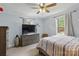 Cozy bedroom featuring neutral tones, a ceiling fan, two windows, and a wooden dresser with television at 4230 Train Chaser Pl, Indian Land, SC 29707