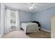 Light blue bedroom featuring a ceiling fan, a large window with curtains, carpet and a bed at 4230 Train Chaser Pl, Indian Land, SC 29707