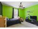 Green bedroom with a window, ceiling fan, a loading sign on the wall and a flat screen TV at 4230 Train Chaser Pl, Indian Land, SC 29707