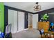 Dark painted bedroom featuring a geometric wall design, two closets, and a wooden dresser at 4230 Train Chaser Pl, Indian Land, SC 29707