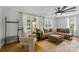 Bright living room featuring a large sofa, modern ceiling fan, and natural light from multiple windows at 4230 Train Chaser Pl, Indian Land, SC 29707