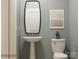 Charming powder room with a pedestal sink, decorative mirror, and neutral color scheme at 4262 Skyboat Cir, Fort Mill, SC 29715