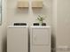Functional laundry room equipped with modern washer and dryer, shelving, and ample space at 4262 Skyboat Cir, Fort Mill, SC 29715