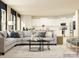 Bright living room featuring a comfortable sectional sofa, stylish rug, and a view of the modern kitchen at 4262 Skyboat Cir, Fort Mill, SC 29715