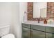 Charming bathroom with brick accent wall, modern vanity with gold pulls, and sleek fixtures at 428 E 33Rd St, Charlotte, NC 28205