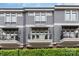 Three-story gray townhome with balconies, black railings, and lush green hedge at 428 E 33Rd St, Charlotte, NC 28205