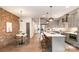 Open-concept kitchen and dining area with brick wall, pendant lighting, and gray cabinetry at 428 E 33Rd St, Charlotte, NC 28205