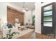 Modern living room featuring exposed brick wall, high ceilings, and hardwood floors at 428 E 33Rd St, Charlotte, NC 28205