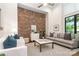 Contemporary living room featuring a brick wall, light gray sofa, and a stylish rug at 428 E 33Rd St, Charlotte, NC 28205