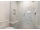 Modern bathroom with a glass-enclosed shower featuring marble-look tiles and a built-in bench at 428 E 33Rd St, Charlotte, NC 28205
