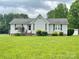 Charming single-story home featuring a lush front yard, manicured shrubbery and inviting front porch at 4317 Waxhaw Indian Trail Rd, Indian Trail, NC 28079