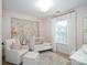 Charming Bedroom with soft pink accents, a crib, and a comfortable armchair at 4323 Bright Rd, Charlotte, NC 28214