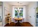Bright dining area features a round table, modern chandelier, and serene backyard views at 4323 Bright Rd, Charlotte, NC 28214