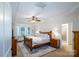 Bright main bedroom with tray ceiling, ceiling fan, and cozy seating area at 4323 Bright Rd, Charlotte, NC 28214
