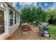 Outdoor patio with dining table, grill, and serene backyard view at 4323 Bright Rd, Charlotte, NC 28214