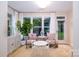 Bright sunroom featuring comfortable seating, a white play table, and a view of the backyard at 4323 Bright Rd, Charlotte, NC 28214