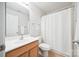 Bright bathroom featuring a white sink, toilet, shower with white curtain, and a mirrored wall cabinet at 444 Battery Cir, Clover, SC 29710