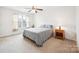 Bright bedroom with a ceiling fan, window, and a cozy-looking bed with light-colored bedding and carpet at 444 Battery Cir, Clover, SC 29710