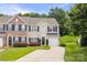 Traditional style home with brick and tan siding, black shutters, manicured landscaping, and a driveway at 444 Battery Cir, Clover, SC 29710