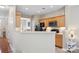 Open kitchen featuring natural wood cabinets, black appliances, and a breakfast bar overlooking the living room at 444 Battery Cir, Clover, SC 29710