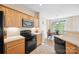 Kitchen featuring natural wood cabinets, black appliances, and a view into the breakfast nook at 444 Battery Cir, Clover, SC 29710